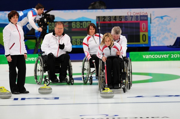 photograph of Canadian wheelchair curling team ready for next shot
