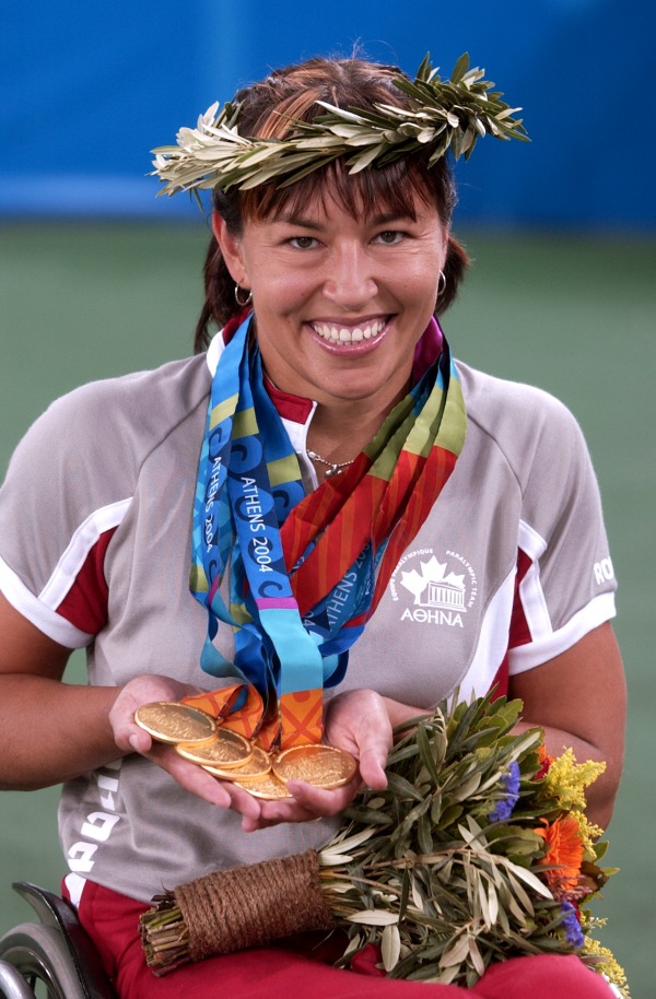 photograph of Chantal Petitclerc holding five gold medals