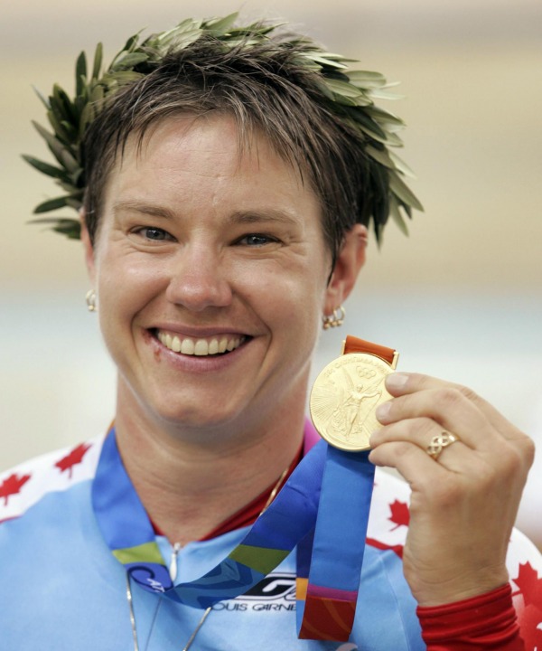 photograph of Lori-Ann Muenzer wearing laurel wreath and holding medal
