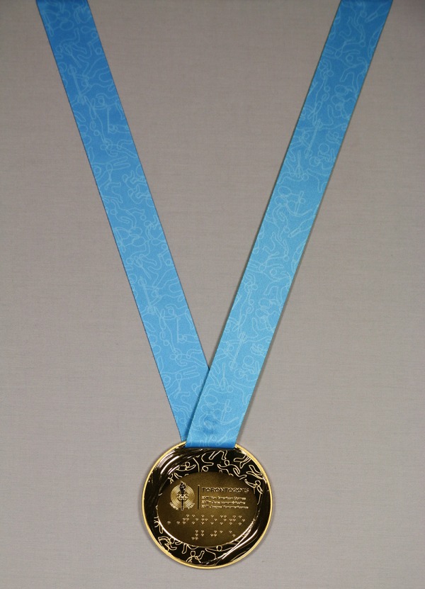 médaille d'or portant le logo des Jeux suspendue à un ruban bleu et vert