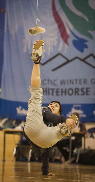 Photo of an athlete at the 2012 Arctic Winter Games kicking a seal target
