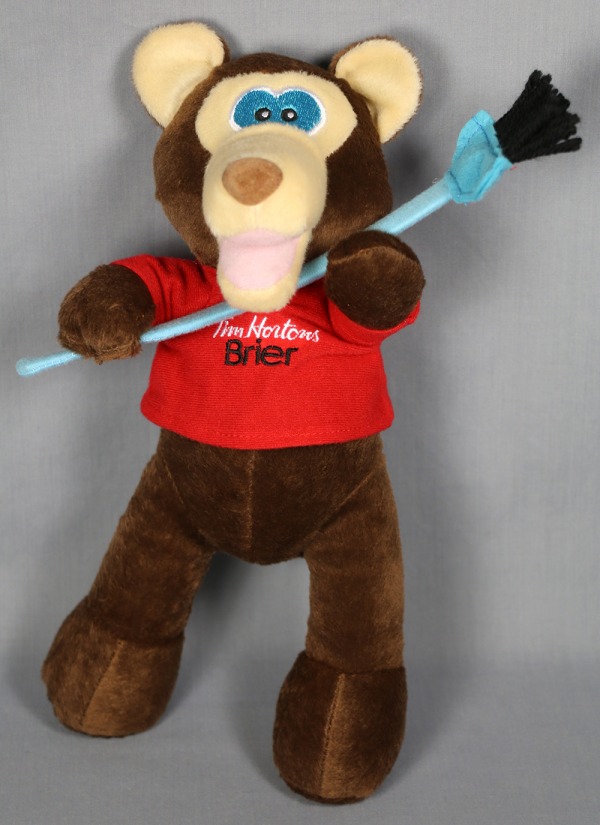 brown toy bear with red shirt and curling broom