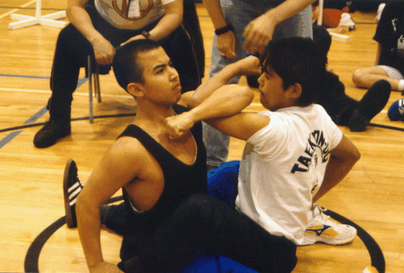 Image of athletes competing in the arm pull at the 1998 Arctic Winter Games